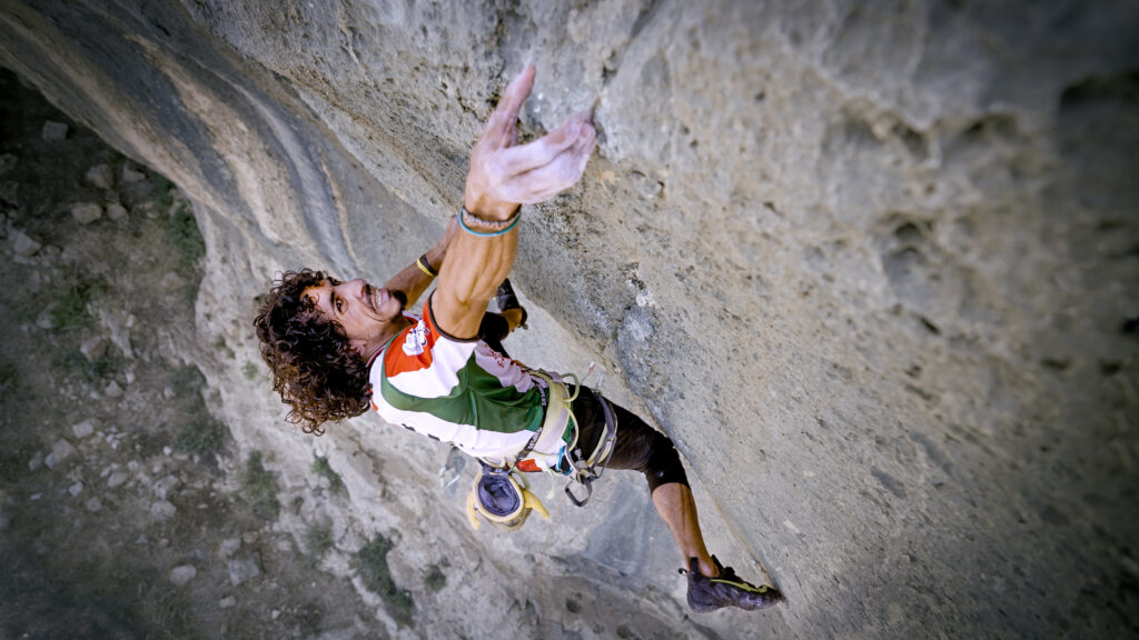 Palestinian man climbing a rock face.