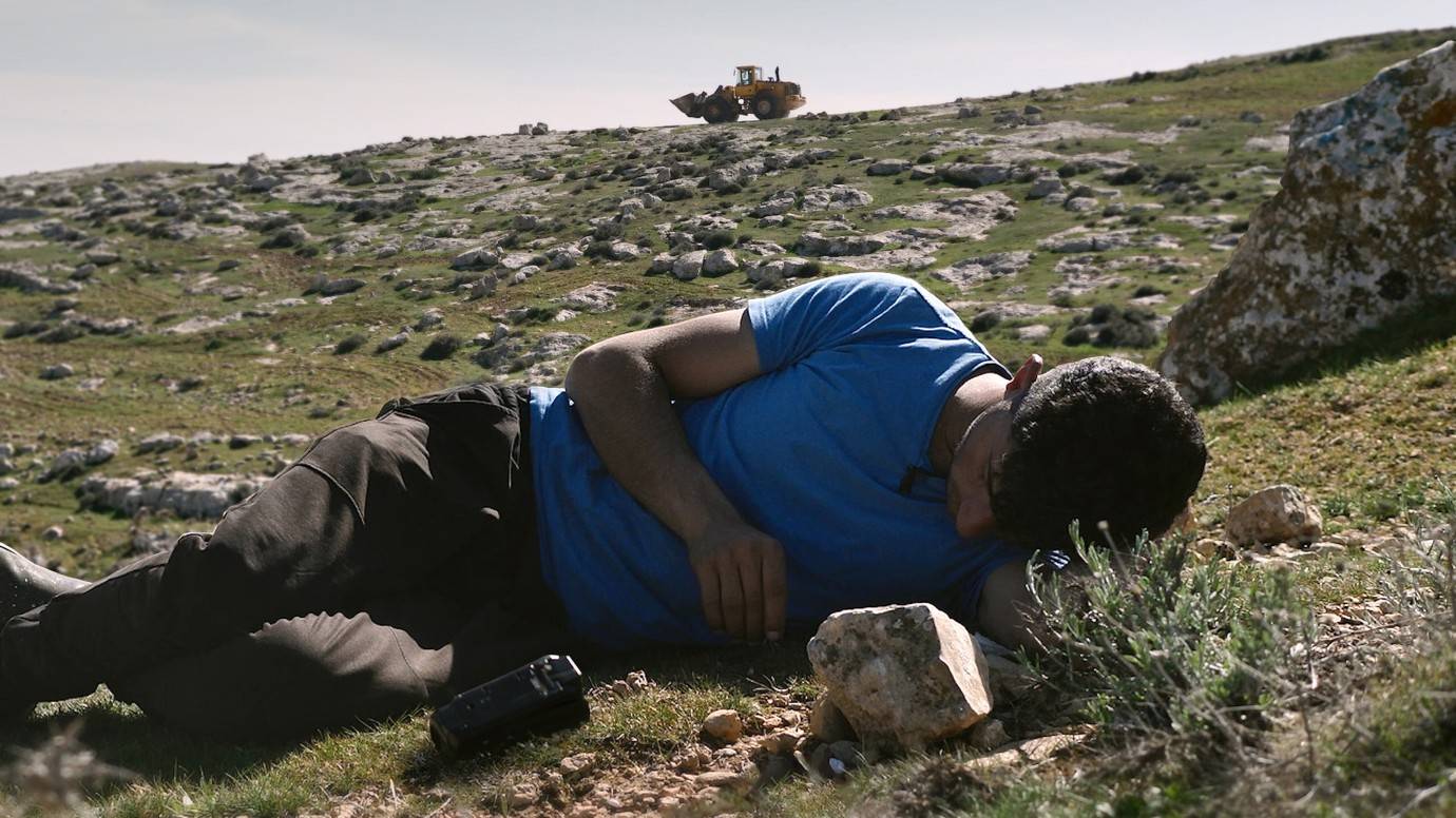 Palestinian man climbing a rock face.